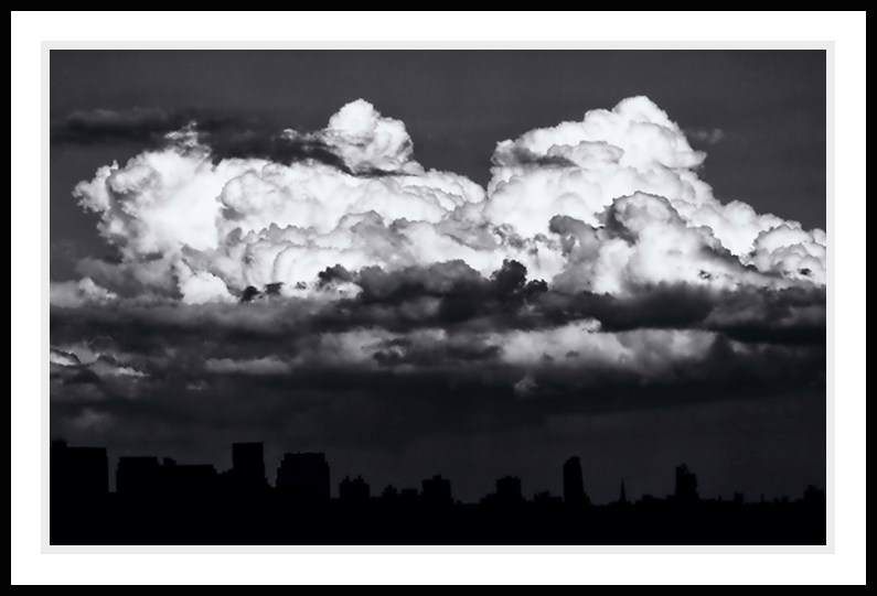 Clouds over a city in dark tones.